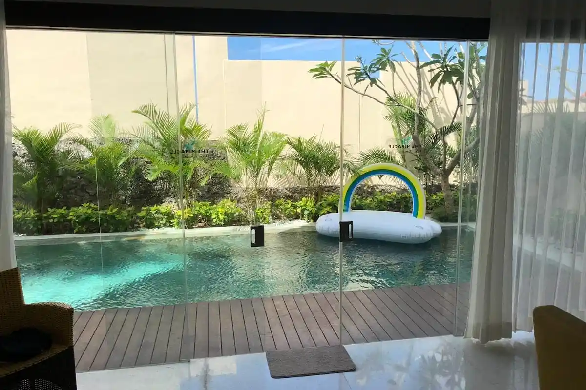 View from a sheltered interior towards a villa pool and garden