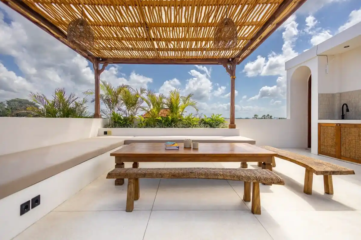 Covered outdoor terrace with a picnic table and open sky