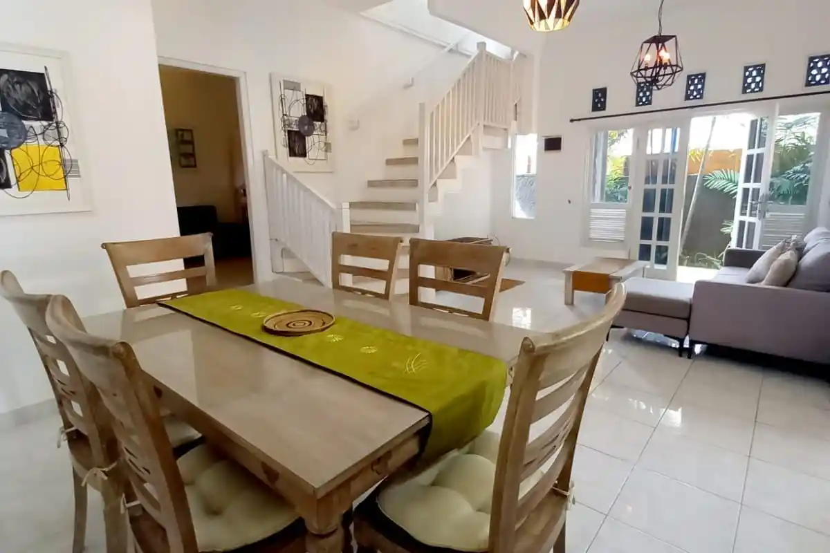 Villa dining table beside a living room and white staircase