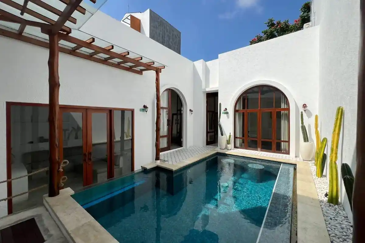 White villa with arched windows around a courtyard pool