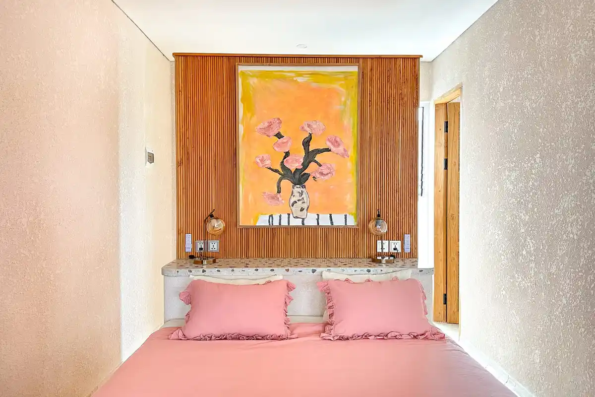 Villa bedroom with pink bedding and a wooden feature wall