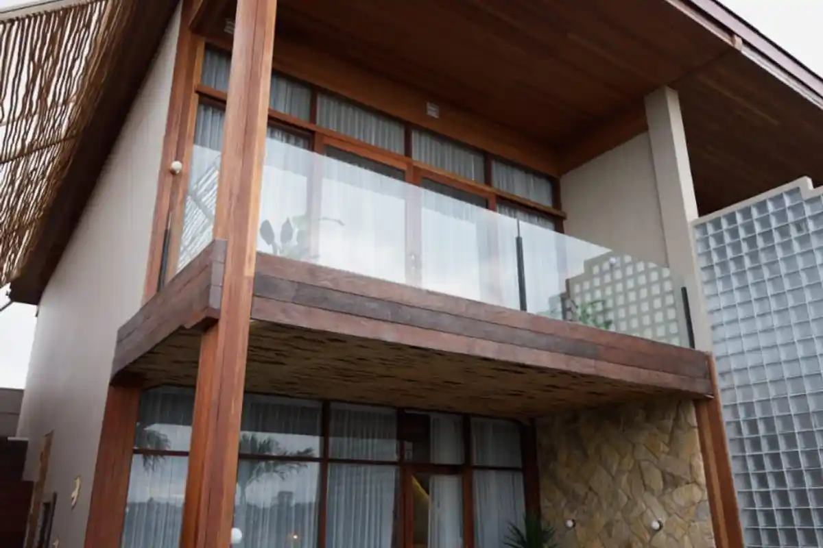 Two-storey villa exterior with timber cladding and a glass balcony
